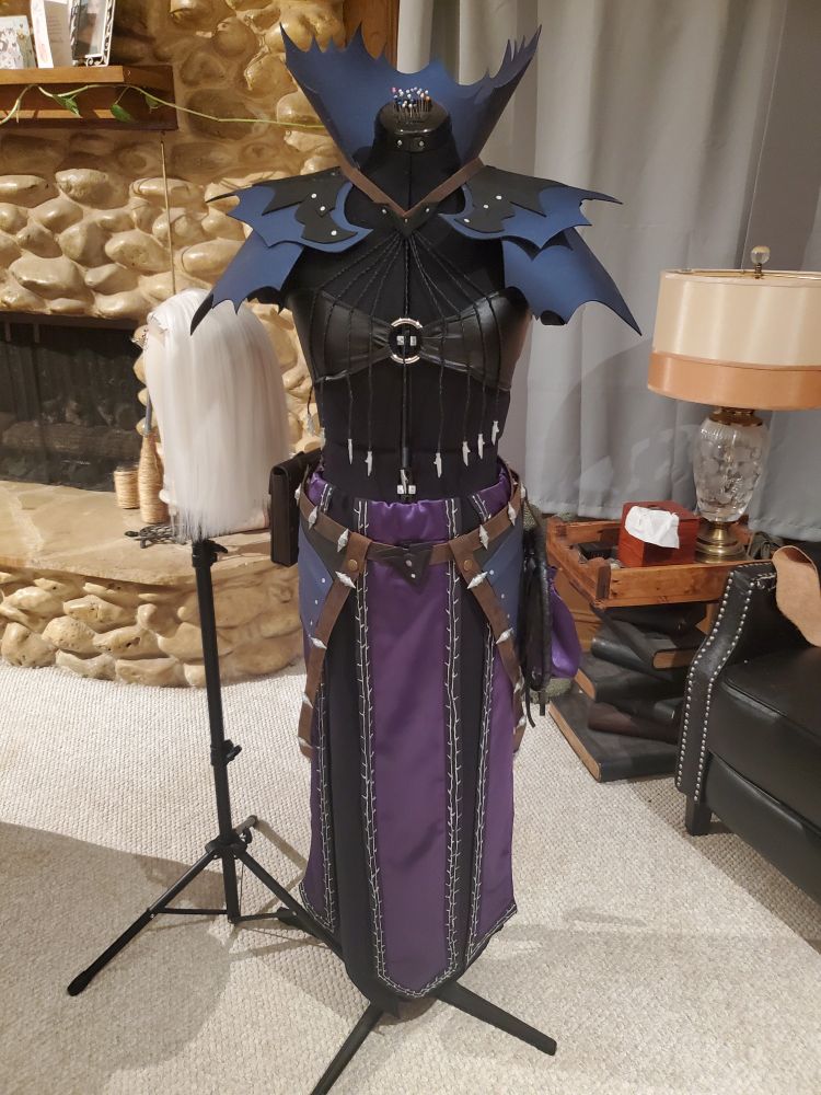 A photo of my Abdirak cosplay on a maniquin, as well as the wig on the eig stand next to it 