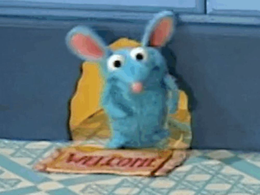 a blue stuffed animal is sitting in a welcome mat .