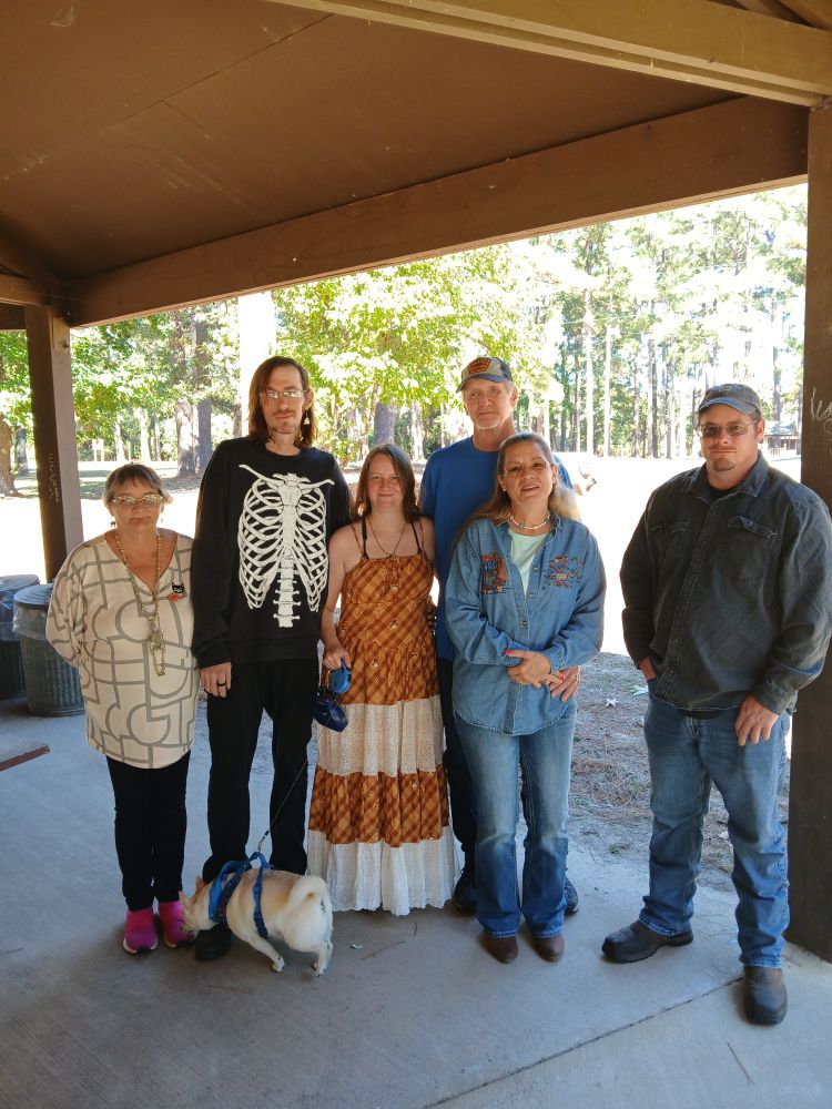 Wedding picture of me in a Howl's Moving Castle inspired dress and Kasey in a skeleton sweater with Gecko in front of us and the rest of my family.