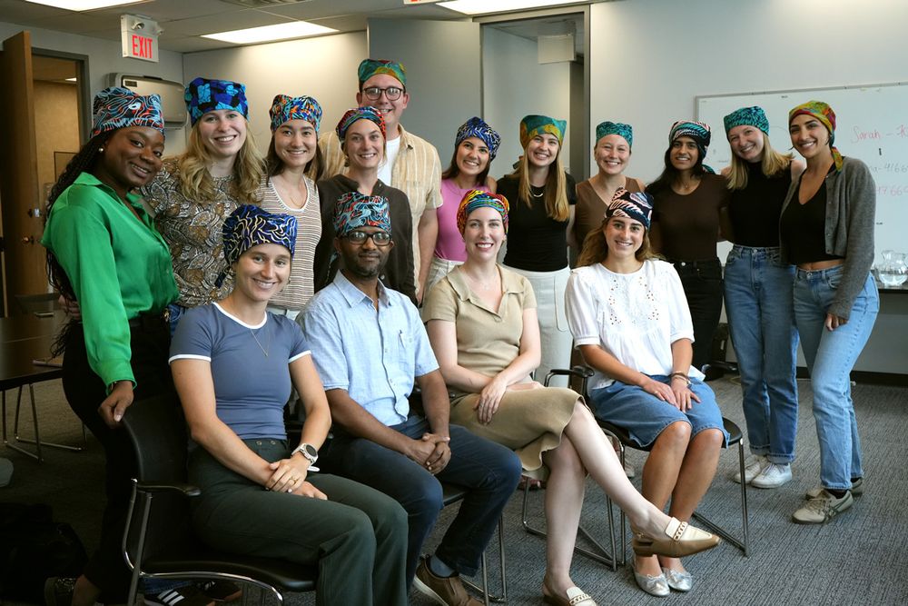 Residents wearing scrub caps, one row standing, one sitting