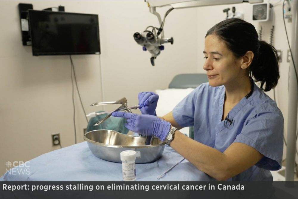 Screenshot of news clip showing doctor demonstrating a swabbing technique with clinical instruments