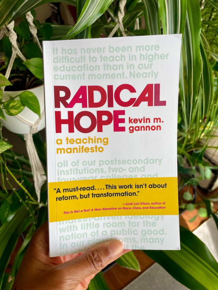 Tolu's hand holding the book, Radical Hope: A Teaching Manifesto, by Kevin M. Gannon.