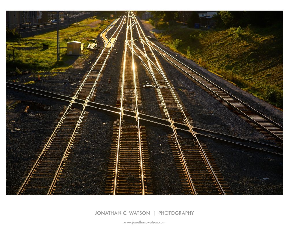 The setting sun glints off a series of converging rails outside of Raleigh, NC