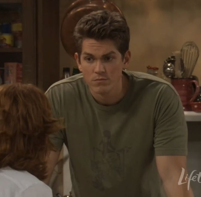 Van from Reba.
A brunette white male wearing a green shirt and standing in the kitchen opposite of a red head (Reba) whose face is not visible to the president l perspective of the viewer 