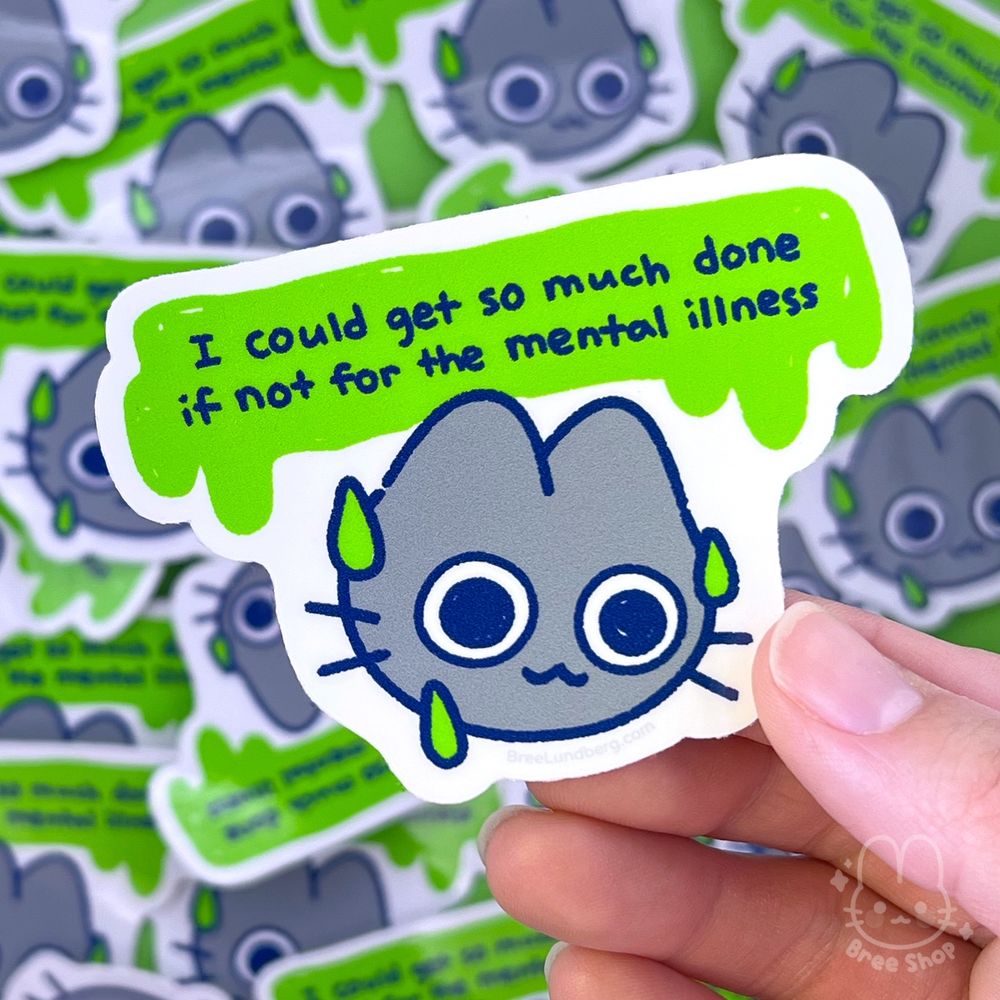 Photo of a stucker of a cute illustrated grey cat's face, its eyes are wide and distressed while smiling and sweating and the words "I could get so much done if not for the mental illness" is above their head in a green melting shape.