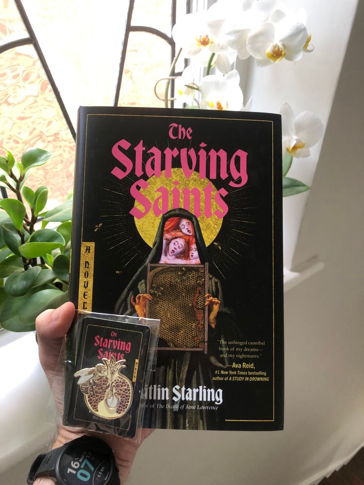 Book with matching enamel pin on a card