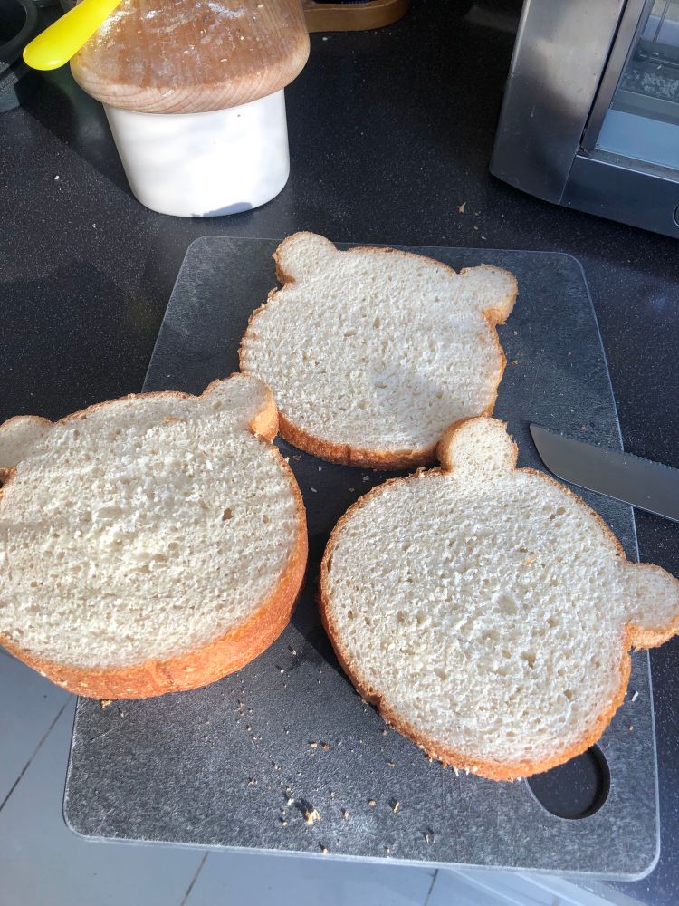 Slices of bear head shaped bread on cutting board 