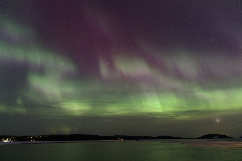 Aurora borealis over a lake in northern Sweden during the winter