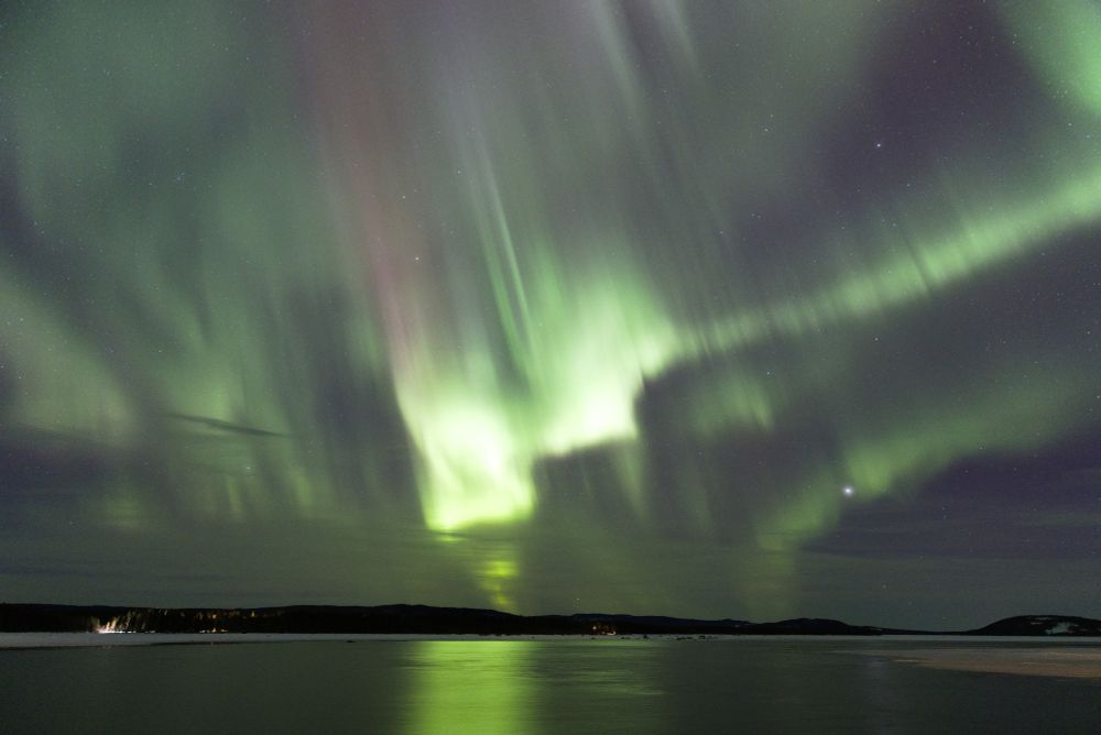 Aurora borealis over a lake in northern Sweden during the winter
