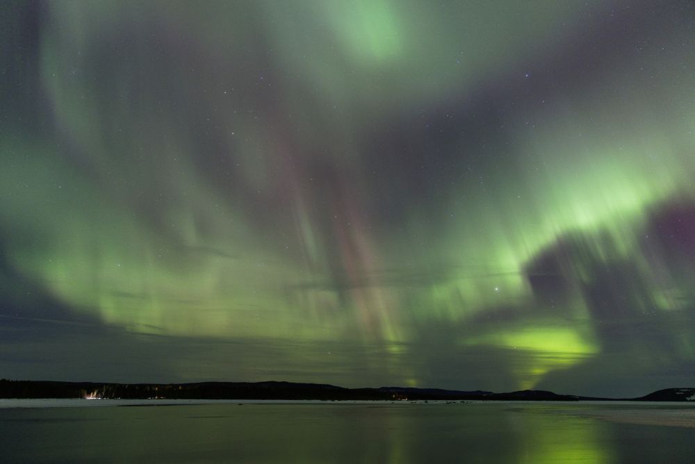 Aurora borealis over a lake in northern Sweden during the winter