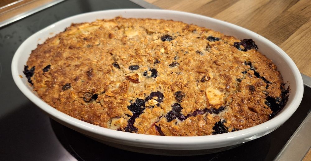 Haferflocken Kuchen in einer weißen ovalen Keramikform, auf Ceranfeld stehend