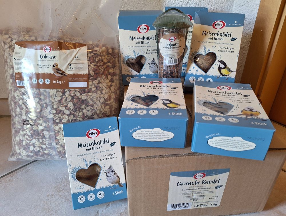 Vogelfutter in unterschiedlichen Verpackungen: Erdnüsse, Meisenknödel, Erdnussspender