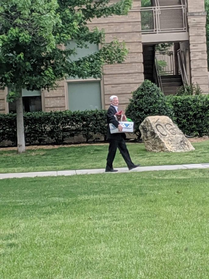 Former University of Oklahoma President James Gallogly unceremoniously carries the contents of his university office across OU’s north quad after having served as OU’s president for nine months. 