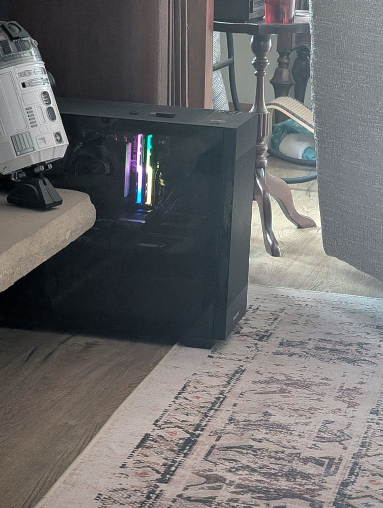 A PC tower that's black with multicolored RAM lit up