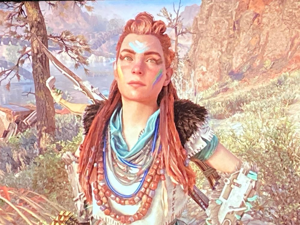 Aloy from Horizon Forbidden West, sporting rainbow pride face paint.