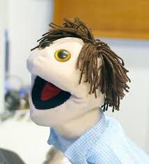 O fantoche Marcelinho, conhecido por ler contos eróticos, sorrindo de alegria com a boca aberta.