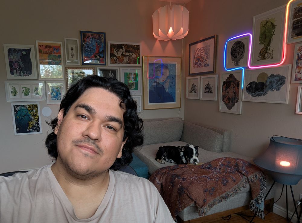 Office selfie with Mina the bulldog puppy snacking in the background.