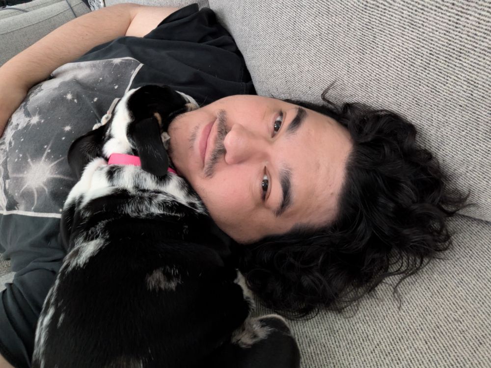 Bulldog puppy Mina asleep on my neck as I'm laying on the couch.