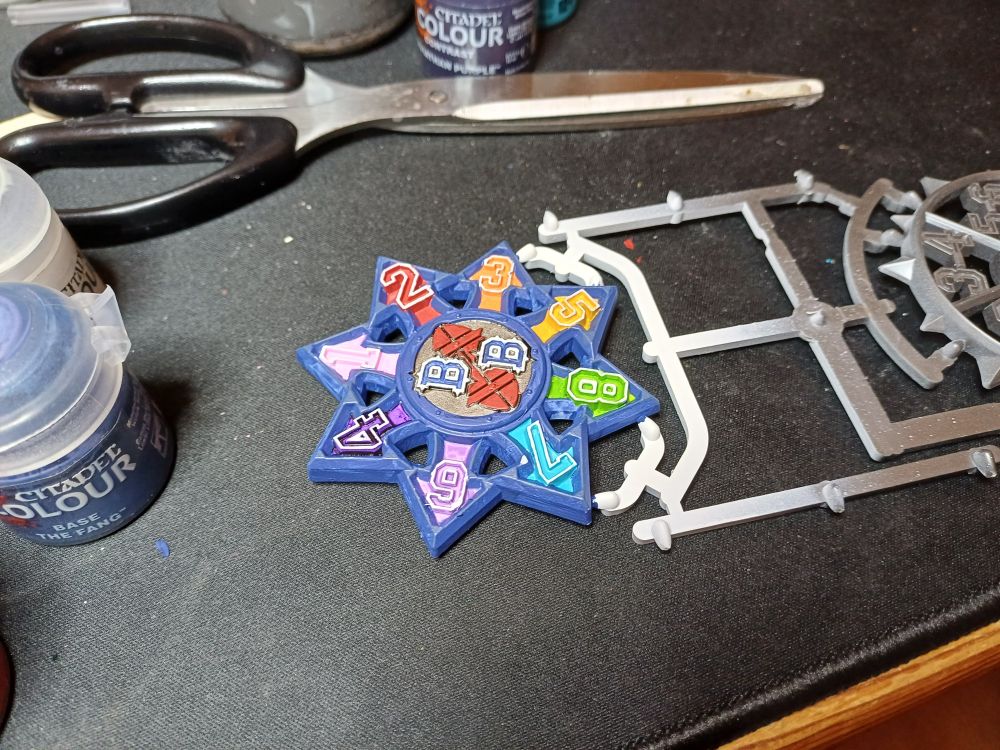 An 8-direction scatter template painted in rainbow colours with a blue trim.