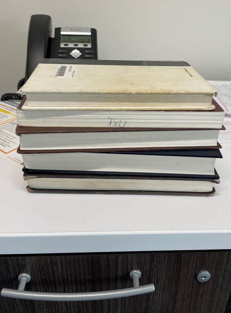 Stack of five books on a white desk
