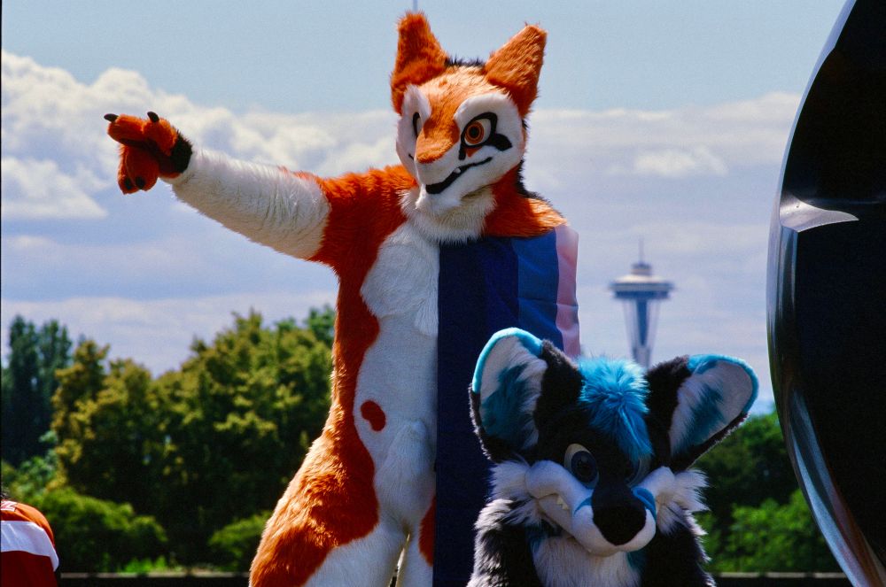 Rikal and Dex pose next to Black Sun in Volunteer Park. The Space Needle can be seen off in the distance.
