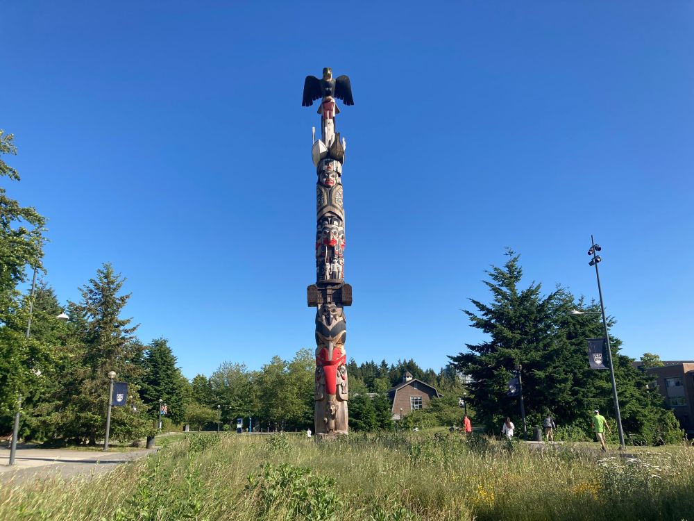 Totem pole in a small meadow against blue skies