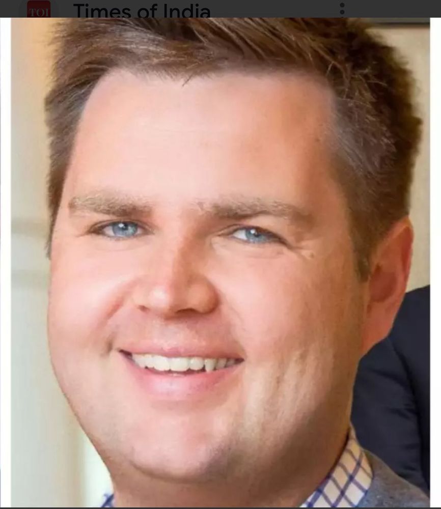 Closeup photo of JD Vance’s face. He’s smiling and has no facial hair. 