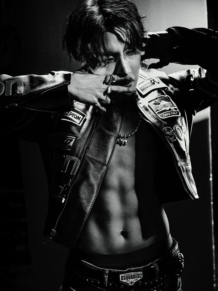 A dark and contrasted black and white photo of j-hope of BTS. He’s wearing a jacket (BARELY) that is unzipped to show every single one of his abs. He’s holding two fingers below his nose as if he’s smelling them and I’m just gonna stop there. 