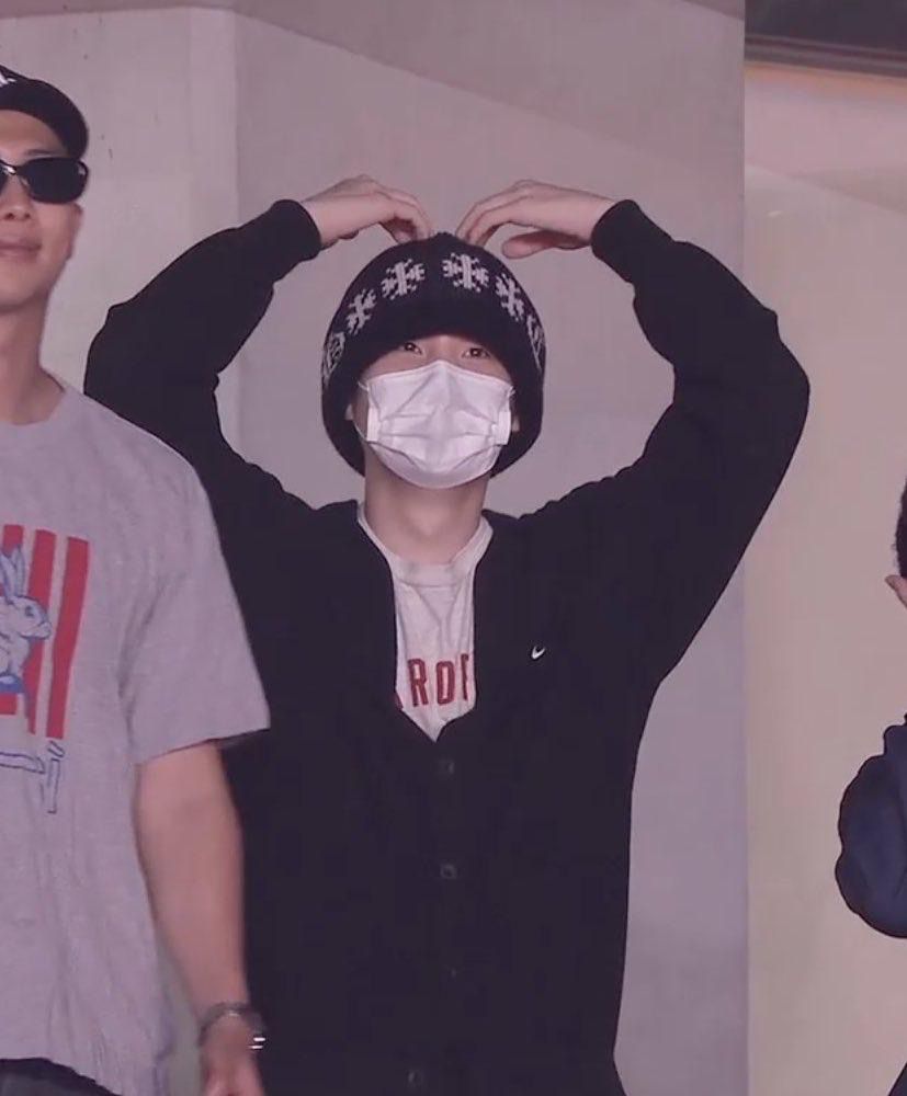 A screenshot of the livestream of Hobi’s encore concert, cropped in on Min Yoongi, who has his hands above his head to form a heart shape. He’s wearing a black beanie and a white medical face mask but you can tell by the shape and sparkle of his eyes that he’s smiling.