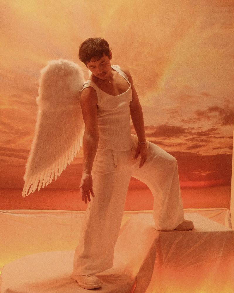 David Archuleta dressed like an angel in white with peach like hues.