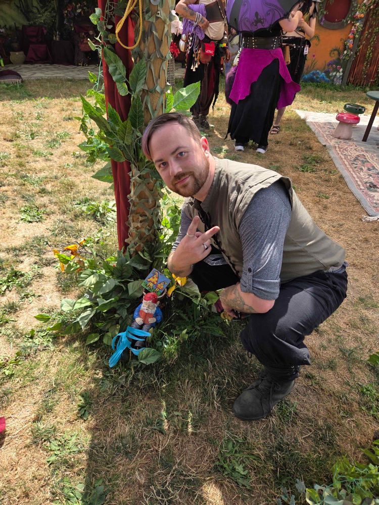 same dude squatting for a selfie with a. garden gnome, as one does