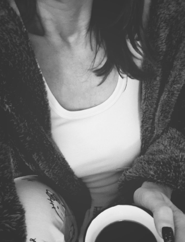 Halbes Selfie mit Kaffeetasse in der Hand s/w