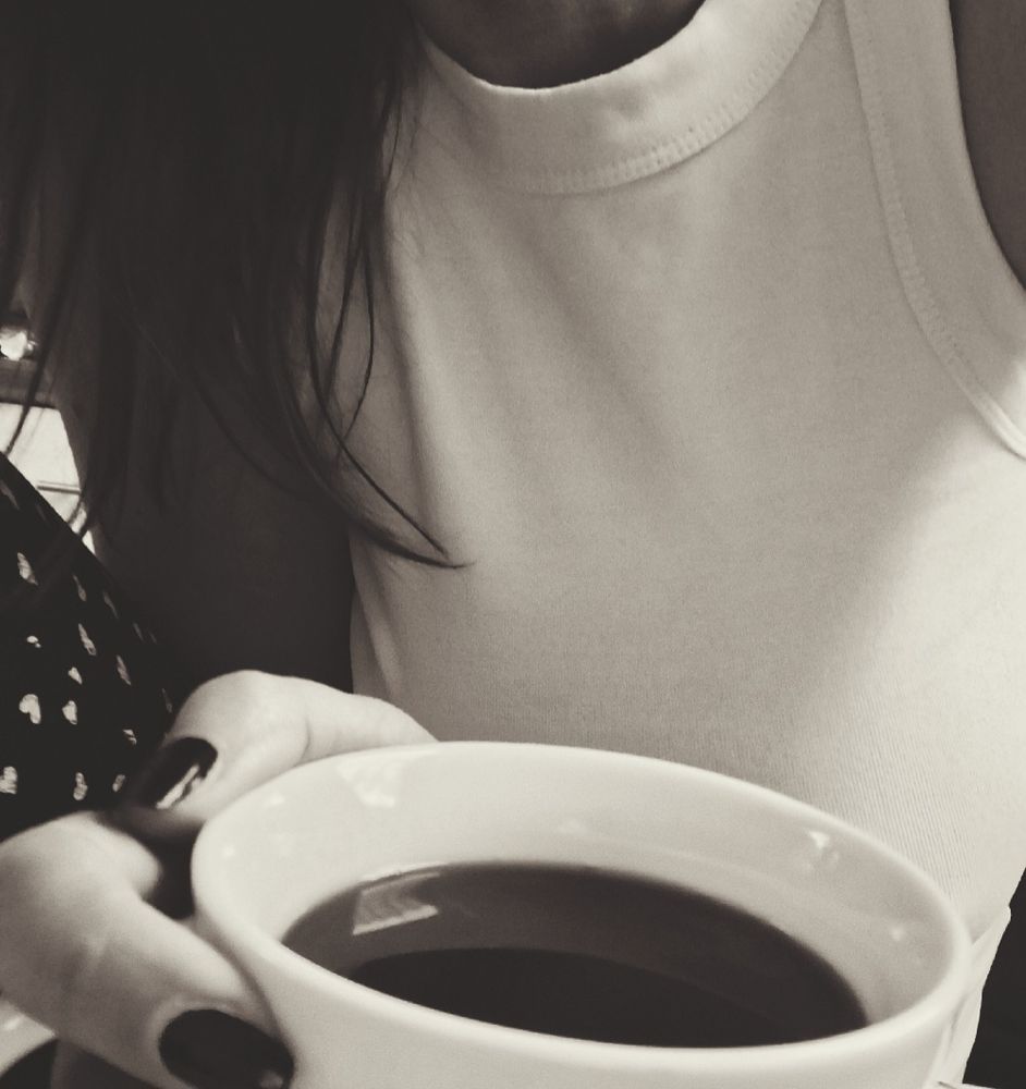 Halbes Selfie mit Kaffeetasse in s/w
