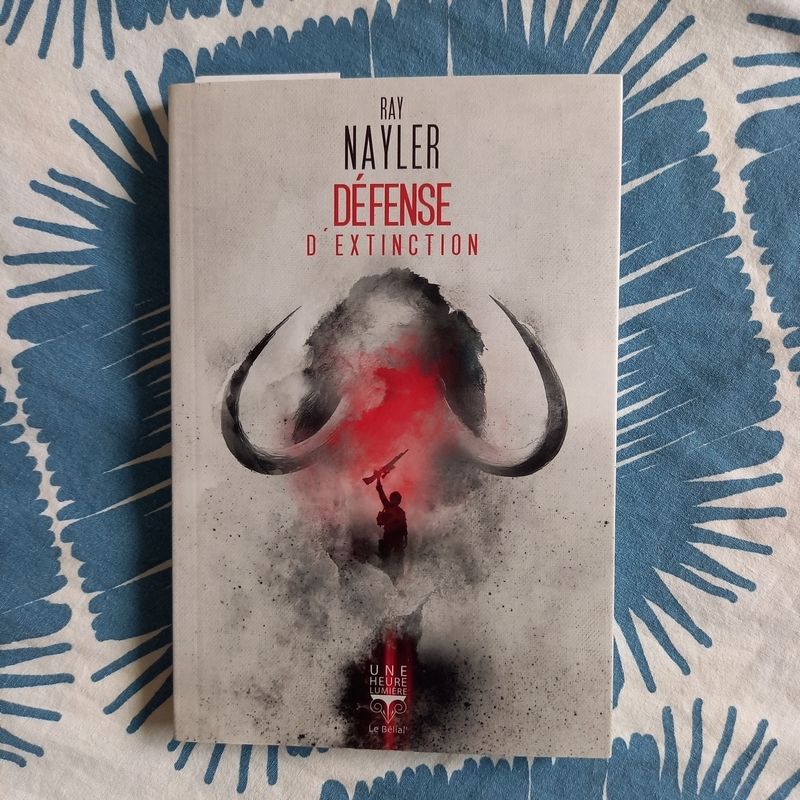 Défense d'extinction, novella de Ray Nayler parue dans la collection Une heure-lumière aux éditions du Bélial. La couverture montre une silhouette humaine tenant un fusil, derrière laquelle se tient un mammouth donc on perçoit la silhouette et ses deux énormes défenses