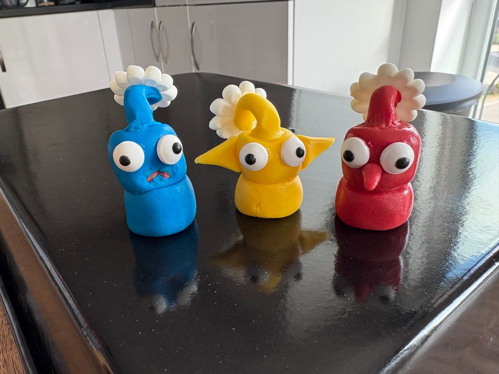 close up of the chunky red, yellow, and blue pikmin i made out of fondant and yes, they did crack me up the whole time i made them