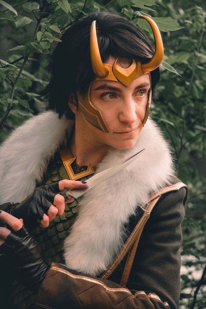 A cosplayer dressed as young avengers Loki and holding a prop knife