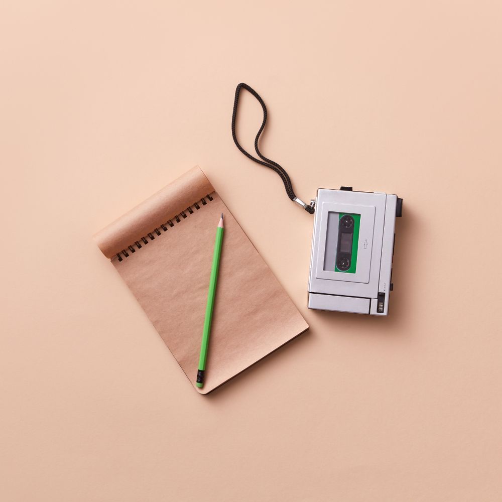 A pad and paper next to a recording device 