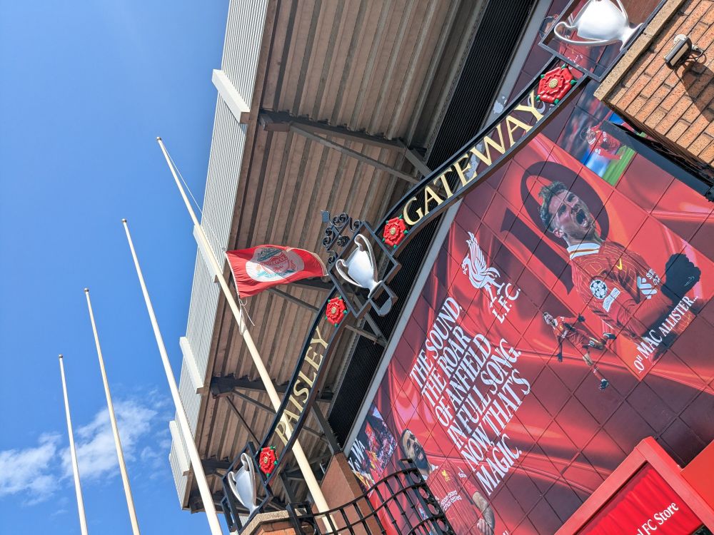 Flag at half mast outside Liverpool's stadium yesterday. The top of the iron work of the Paisley Gateway, named for Bob Paisley, the top of the stand and a huge poster showing some of the players is also showing 