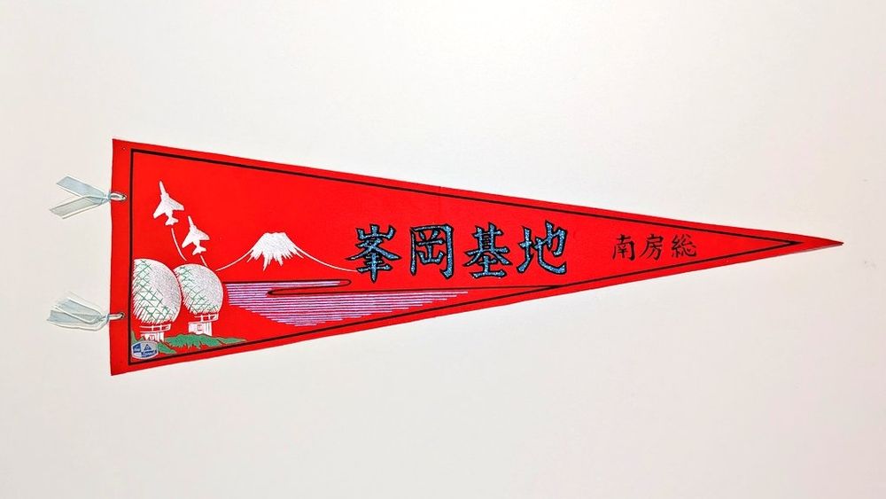 1, 峯岡基地のペナント。赤い布にイラストをプリント。旗の左に水色のリボン (オーガンジー) 2本付き。