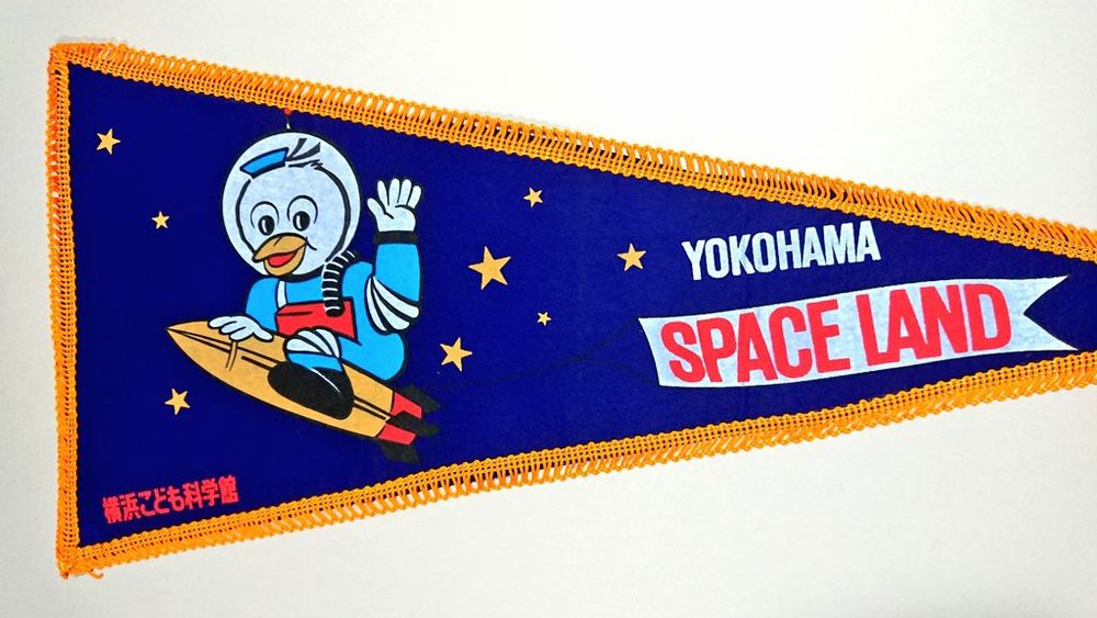 2, イラストはロケットにまたがる宇宙服を着たカモメのキャラクター。旗の左下に和文の小さいサブタイトル、