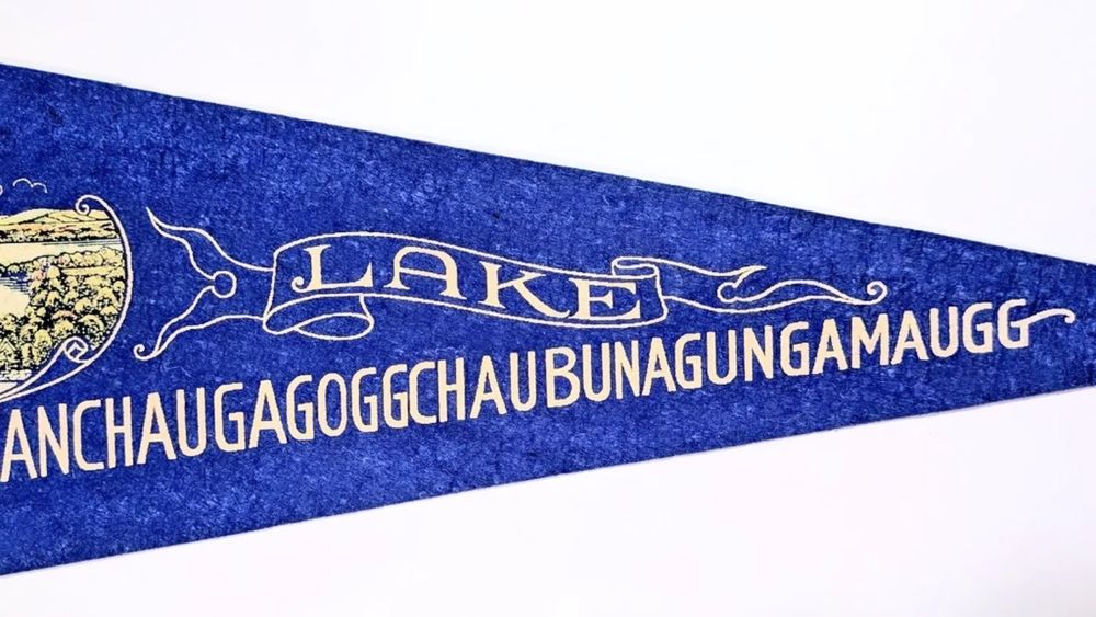 4. The title is in English. "LAKE Chargoggagoggmanchauggagoggchaubunagungamaugg" (white) is written in a font with decorative initials. Note that the font for "LAKE" is Century and is decorated with a bow frame. 