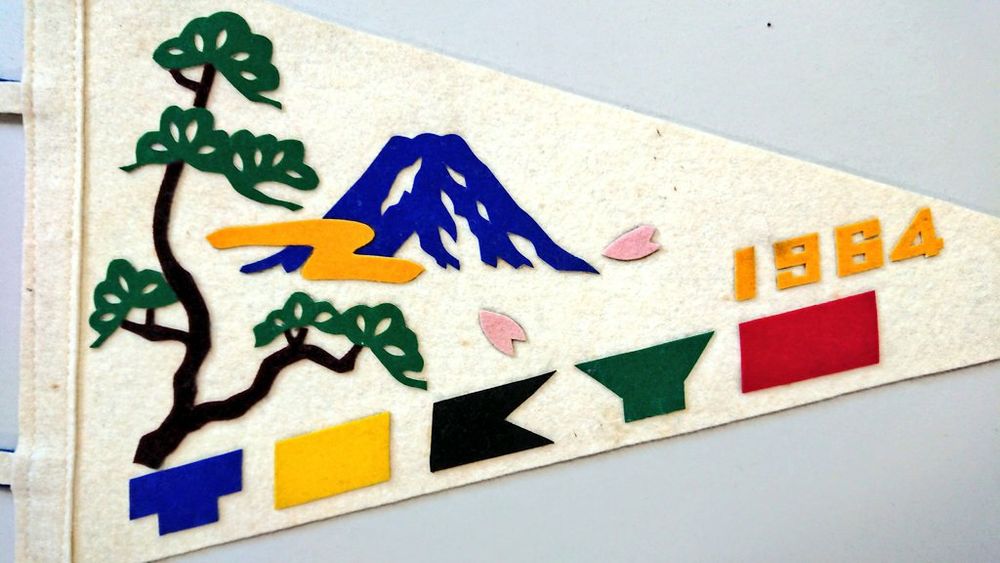 3, タイトルは英文。幾何学的にアレンジされた英字で "TOKYO"  （紺,黄,黒,緑,赤）、 "1964" （濃黄）。