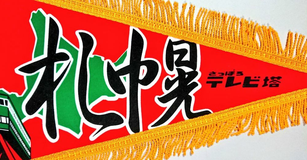 4, タイトルは和文。筆文字の漢字で "札幌" （黒）。旗の右端に公式のロゴデザイン、"さっぽろテレビ塔" （黒）。