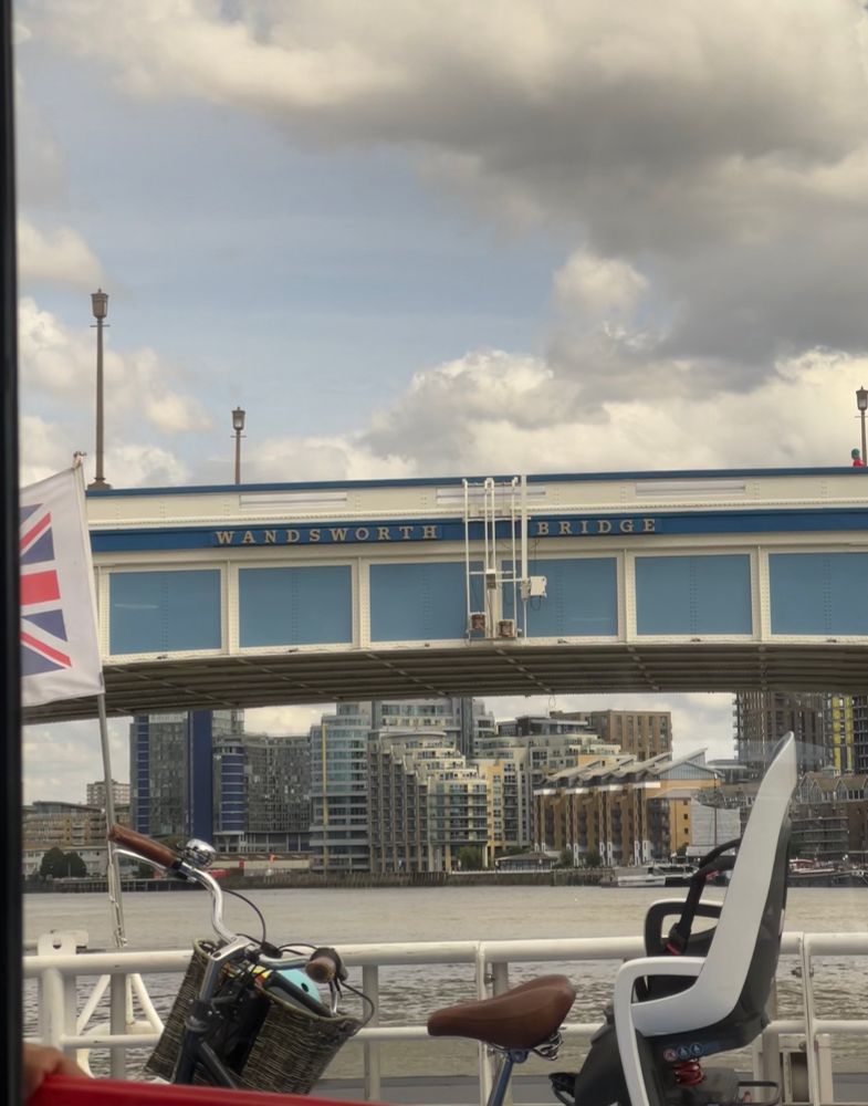 Photo of a bike with a child seat attached on a boat on the Thames, just ahead of Wandsworth bridge 
