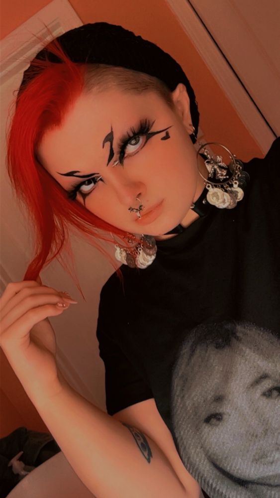 portrait selfie - me!! (he/him!!!)
a white genderfluid, gender nonconforming (gnc) person seen from the bust up. he has fluffy pink hair cut in an undercut and floppy mohawk, facial piercings, jingly baphomet earrings, and a sabrina carpenter t shirt on