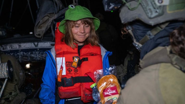 Greta in a frog hat and life jacket 