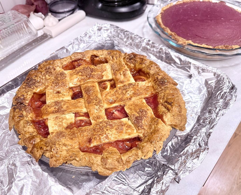 A strawberry lemon pie and purple sweet potato pie cool on the kitchen counter 