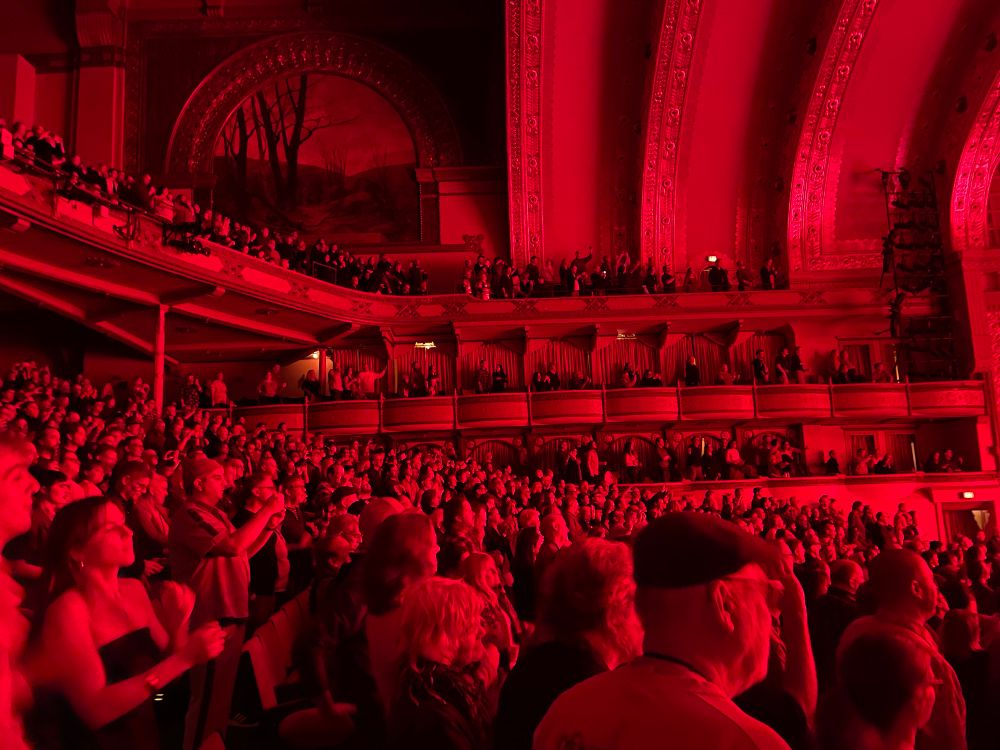The audience at the Auditorium Theater bathed in red light dancing to Burning Down the House 