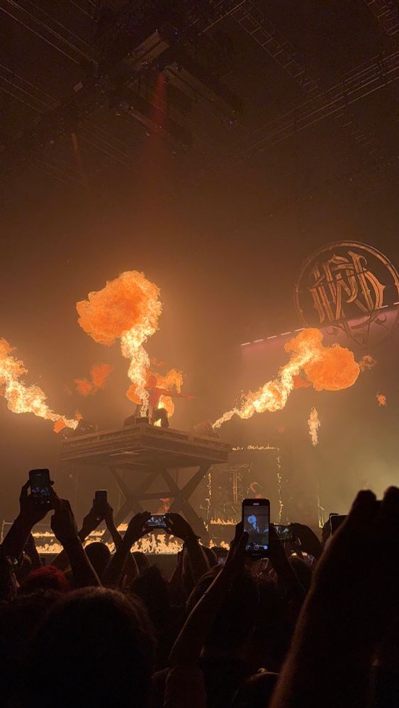 Winston, cantante de Parkway Drive, sobre una plataforma elevada rodeada de lanzallamas. 