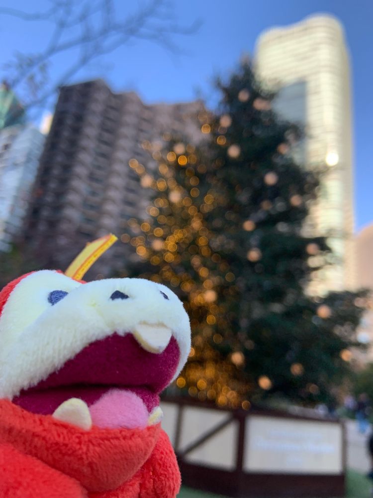 斜め右上を見てるホゲちゃんとぼやけたクリスマスツリーとビル